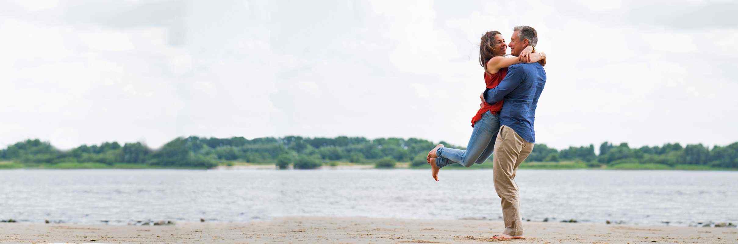 Paar umarmt sich schwungvoll am Strand, Norddeutsche Paarakademie, Seminare für Paare