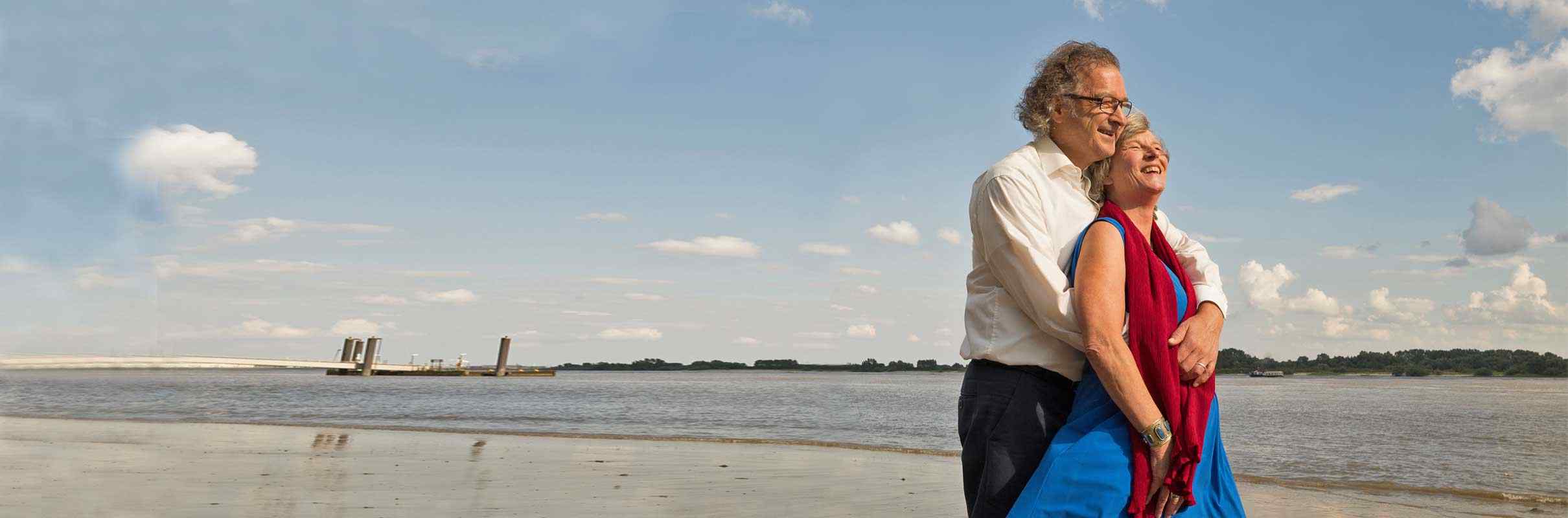Mann umarmt Frau liebevoll am Strand, Norddeutsche Paarakademie, Paartherapie
